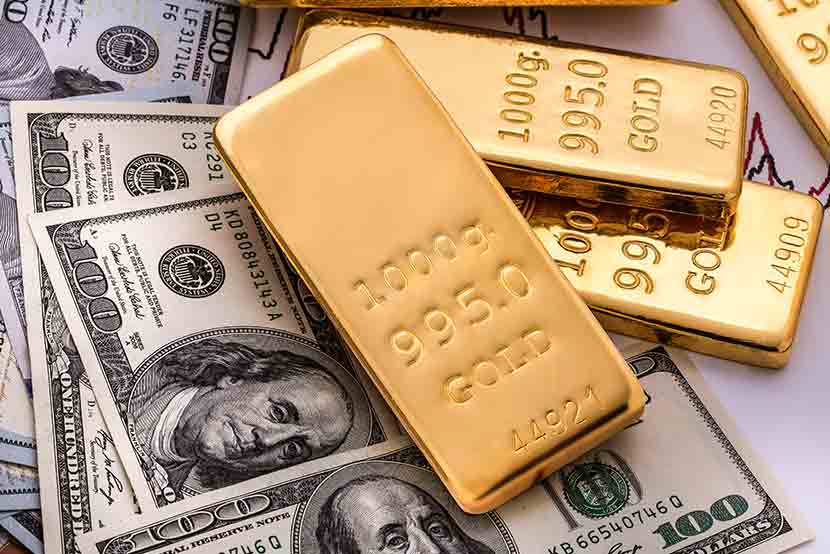 Gold bars stacked on an array of one hundred dollar bills