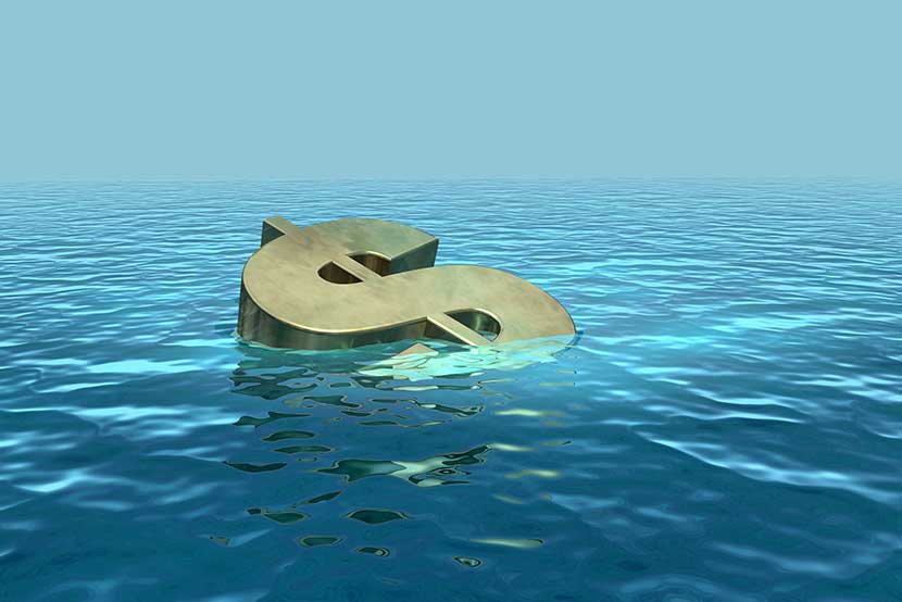 Gold dollar sign sinking in ocean of water