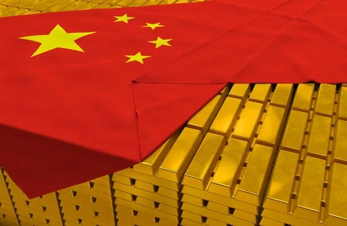 Massive expansive of stacked gold bars peeking out from under Chinese flag, draped over them