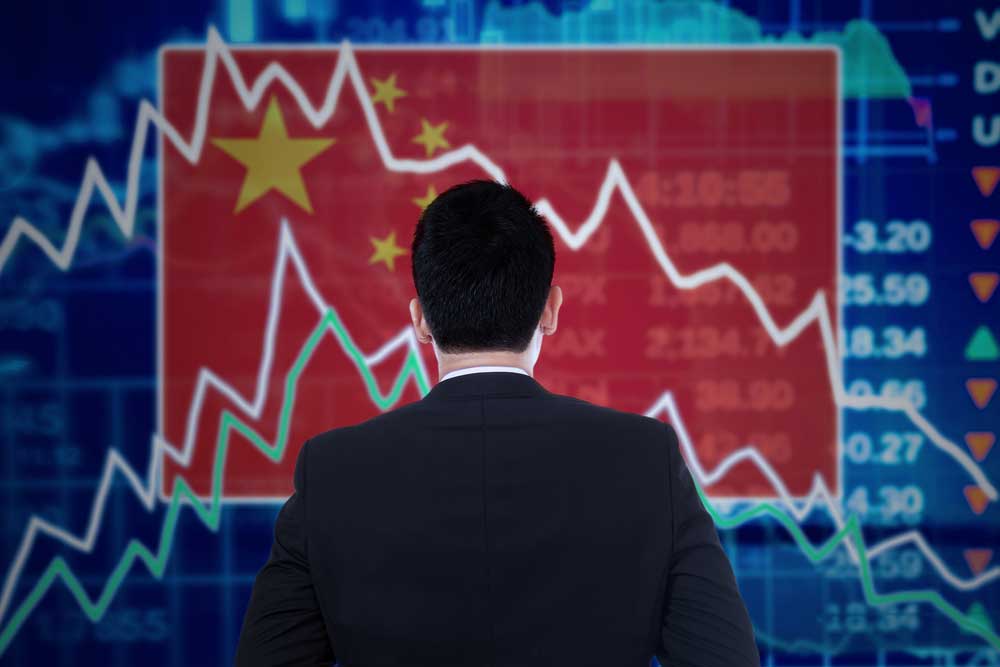 Chinese businessman staring at stock market screen as China stock trading halts after steep drop