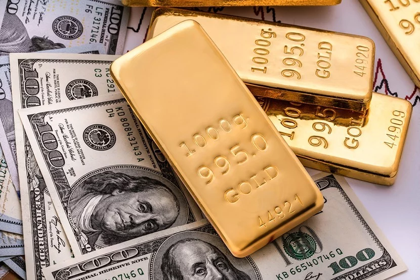 Gold bars sitting on top of dollars