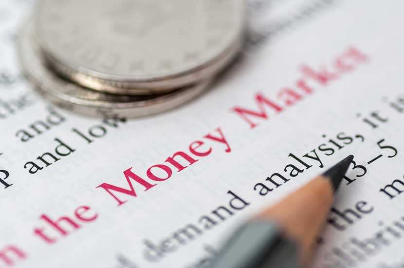Coins sitting on top of article with Money Market visible and pencil close up pointing to demand analysis