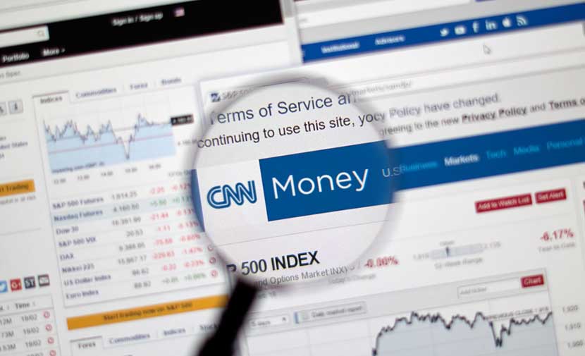 cnnmoney Magnifying glass hovering over CNN Money website
