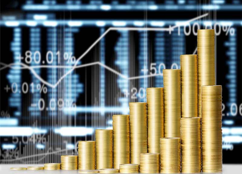Stacks of Gold coins against stock market graph, with gold racing to highest price in over 2 years
