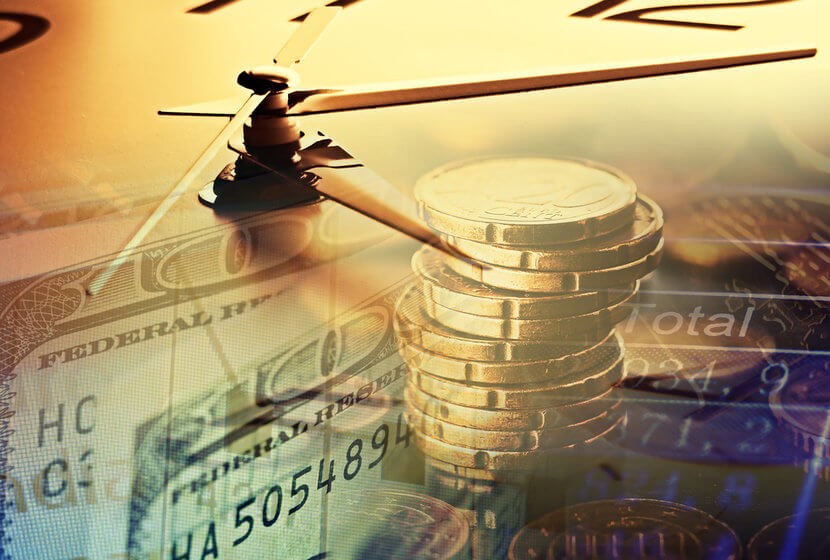 Gold coins against backdrop of clock, US currency, and monetary calculations