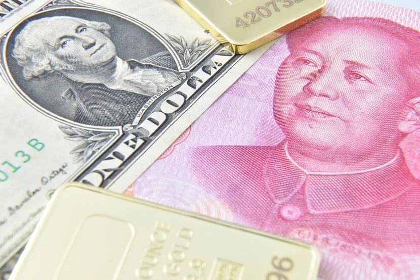 The US dollar, Chinese Yuan, and various gold bars grouped together