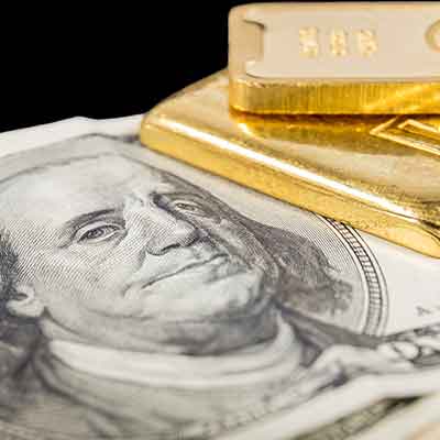 zoomed-in $100 bill with corner of two gold bars on top