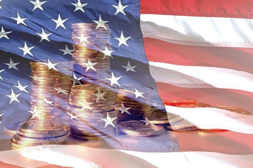 Stacks of gold coins against backdrop of American flag, a celebration of National Coin Week