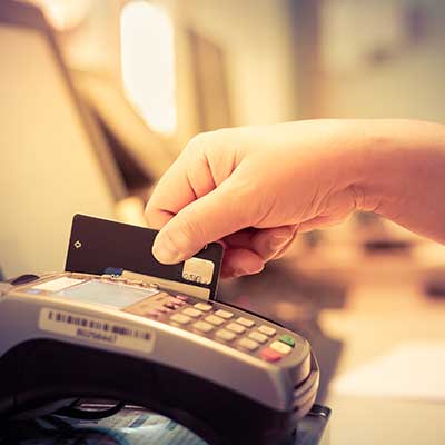 hand swiping credit card through credit card machine