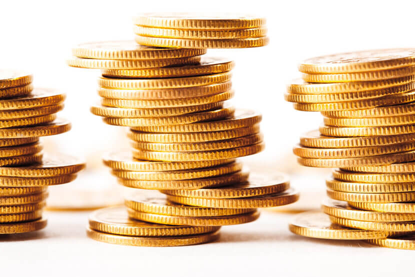 stacks-gold-coins Three stacks of shimmering, teetering gold coins