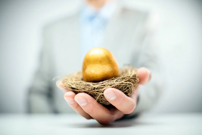 whats-best-retirement-plan-for-me Businessman holding out nest with golden egg