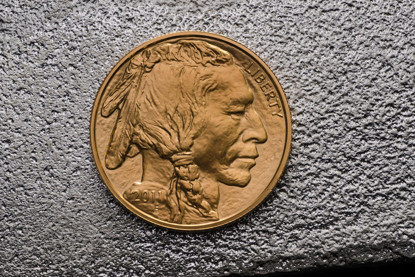 Indian head on Gold American Buffalo Coin against silver backdrop