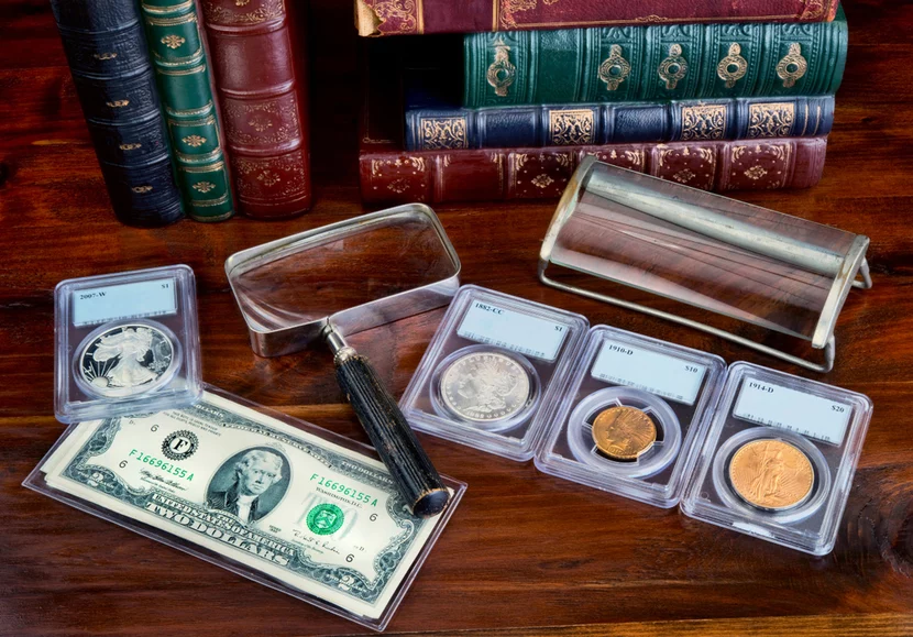 proper-coin-handling Gold and silver coins in protective slabs on wooden table with money and magnifying glass