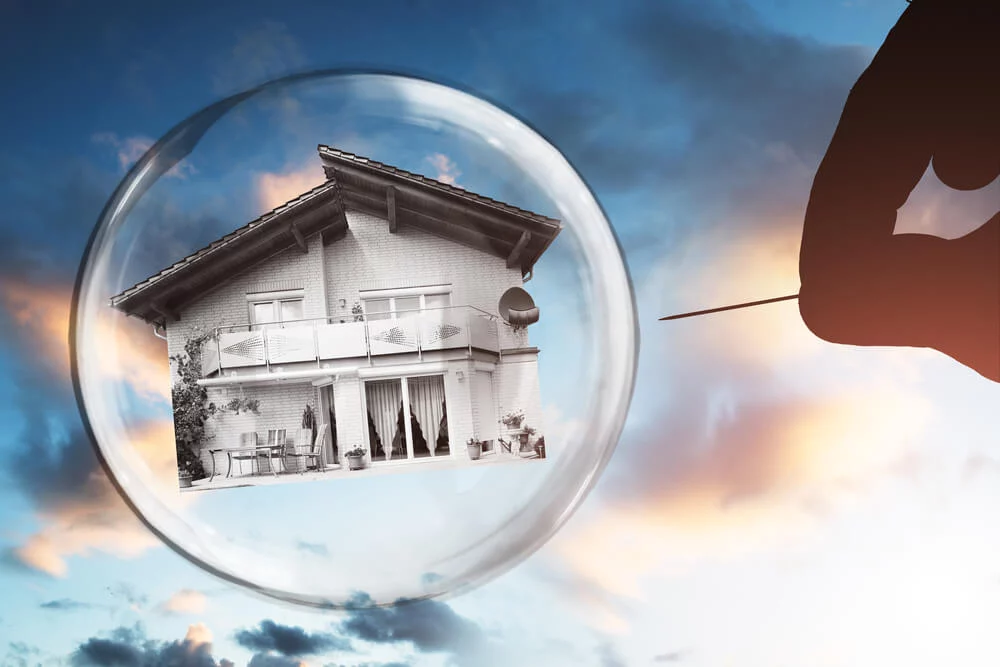 Human Hand Poking House And Bubble With Needle Against Cloudy Sky Human hand poling house and bubble with needle against cloudy sky