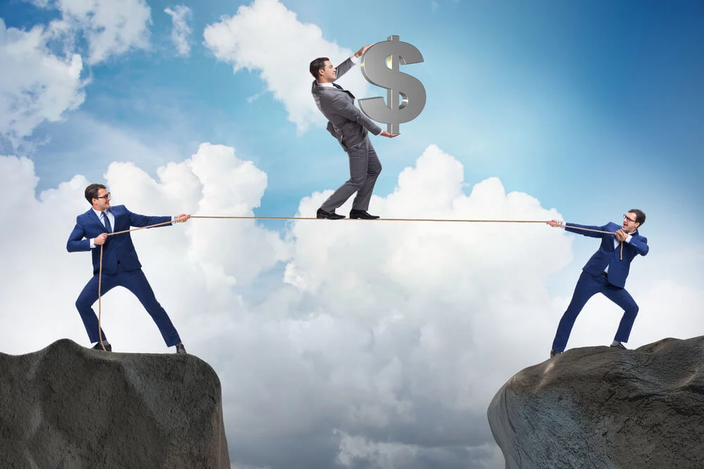 Businessman walking on tight rope holding a dollar sign