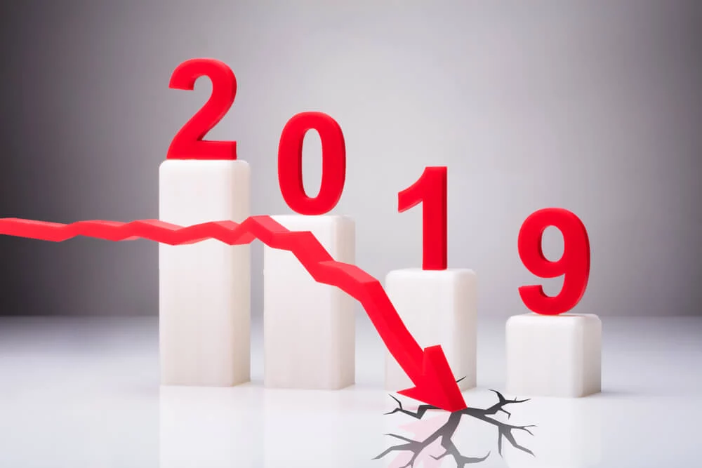 Red Arrow Cracking White Surface In Front Of Decreasing Year 2019 Graph 2019 with red arrow descending and cracking ground