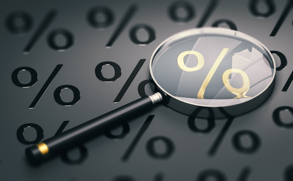 Magnifying Glass Laying on Top of Percentage Symbols
