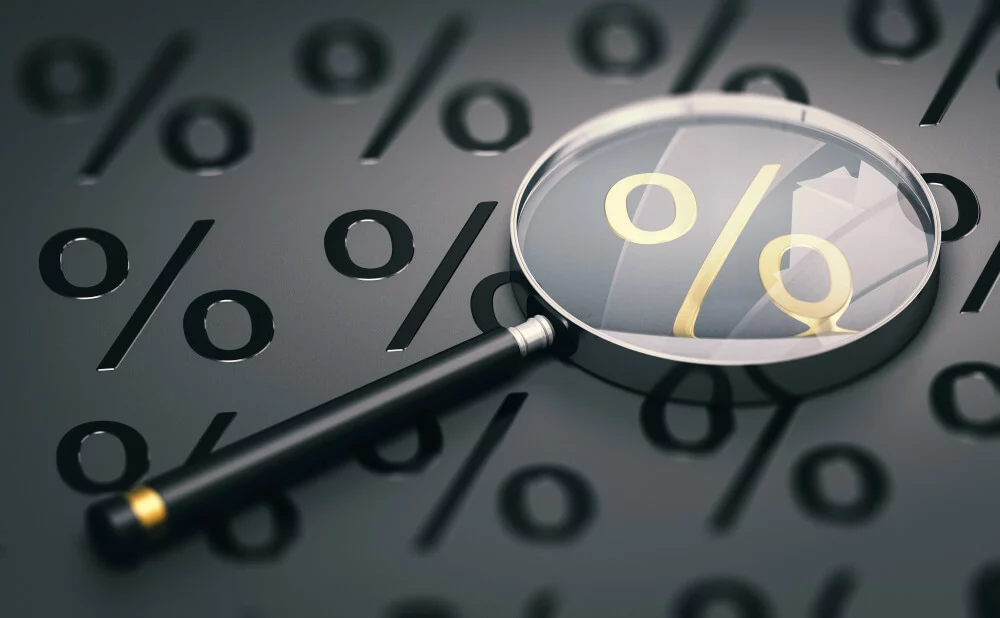Magnifying Glass Laying on Top of Percentage Symbols