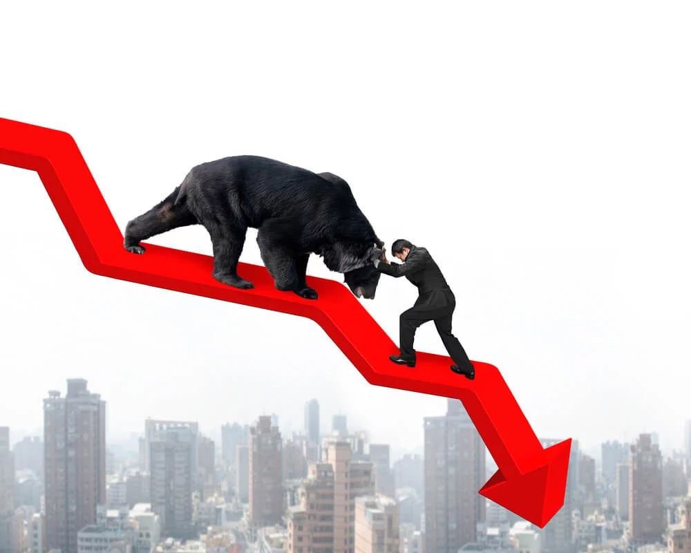 Graphic that represents a recession with a bear crawling down a red trend line and a businessman attempting to push the bear back on top of a cityscape