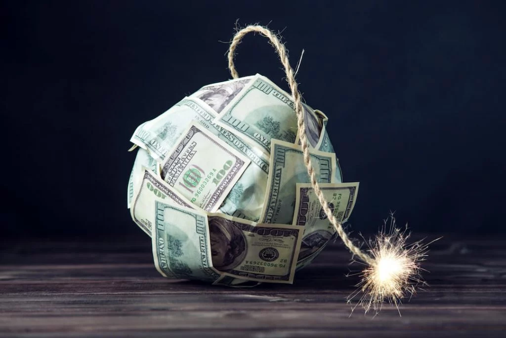 Dollar bills in the shape of a bomb with the fuse lit