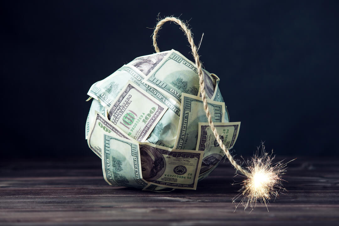 Dollar bills in the shape of a bomb with the fuse lit