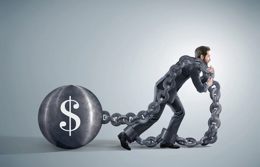 Man pulling a dollar superimposed on a ball with a chain
