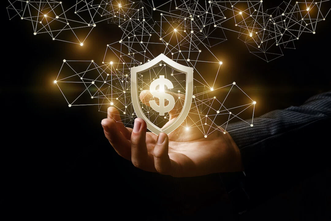 Gold shield with dollar sign inside held up by businessman hand