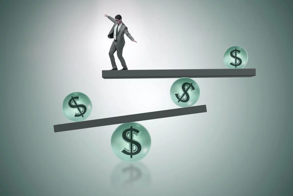 Man trying to retain his balance on various dollar signs