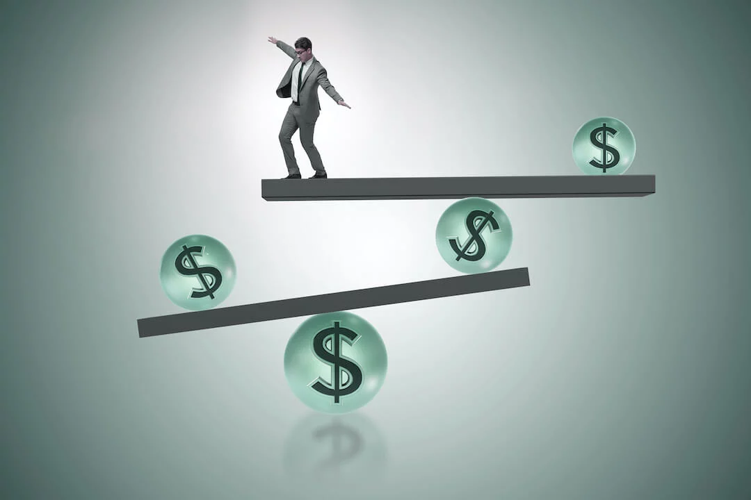How Stable Are Your Holdings? Man trying to retain his balance on various dollar signs