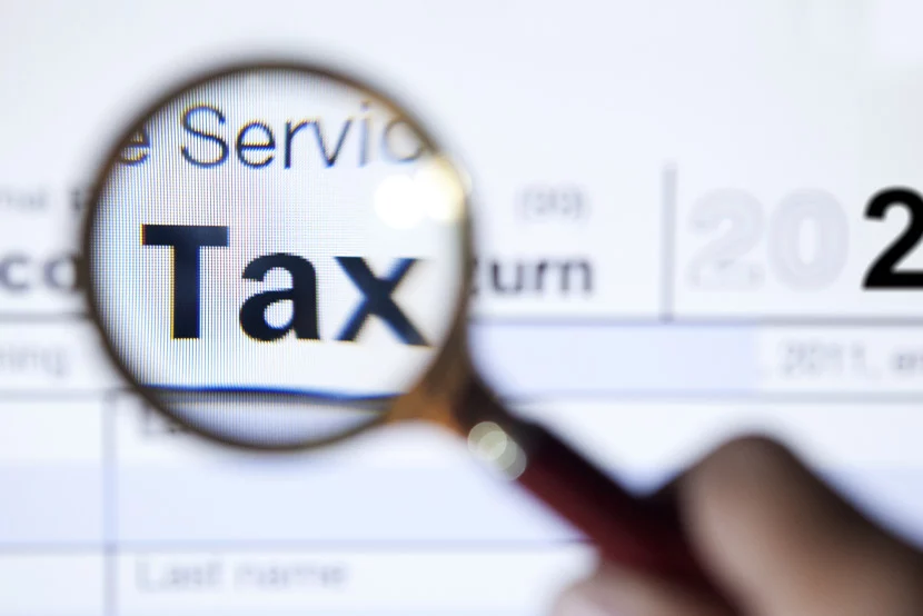 what-we-know-so-far-about-the-proposed-tax-hike_830x554 Magnifying glass on top of tax return