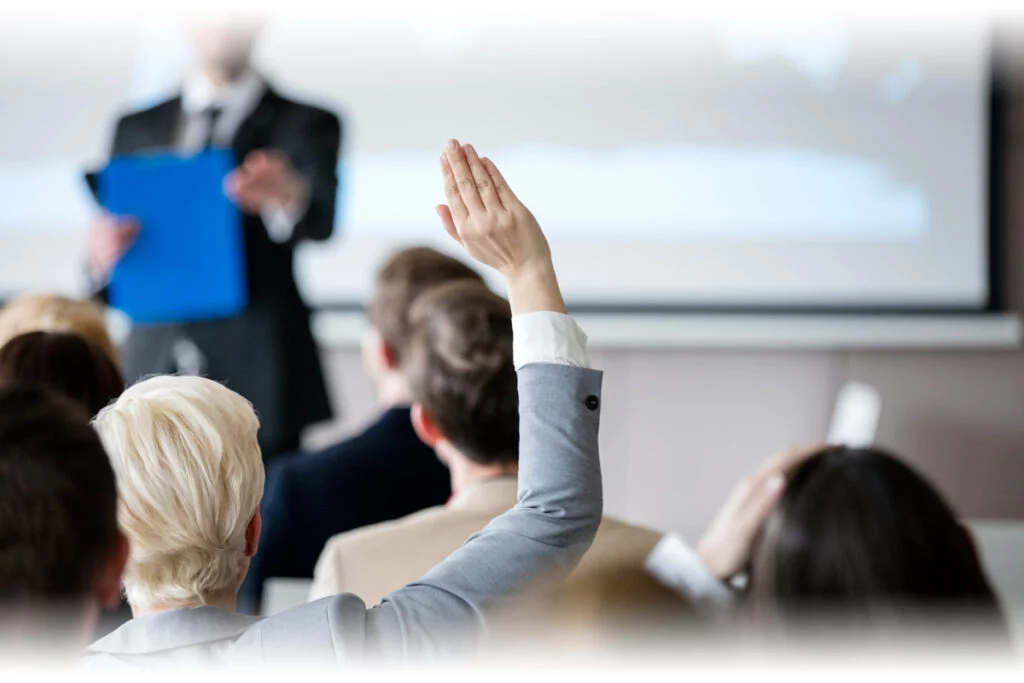 Woman raising hand during seminar