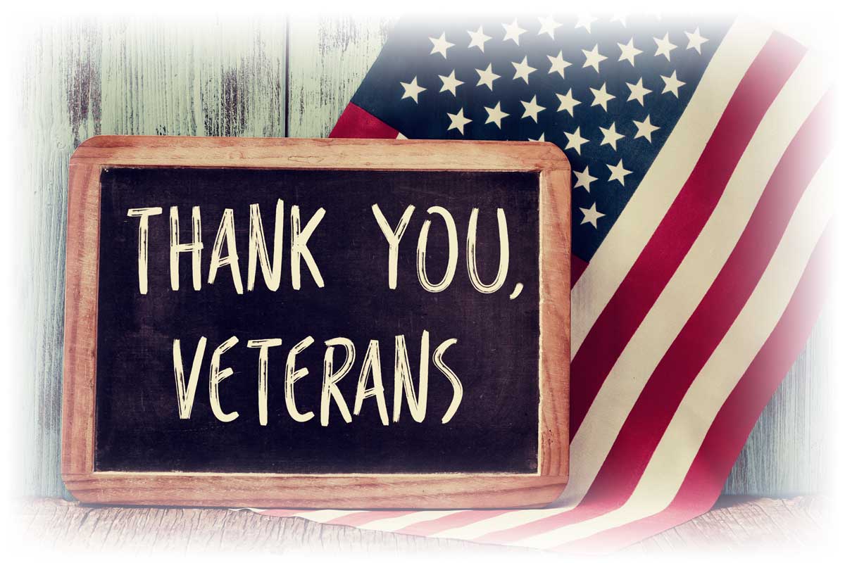 Chalkboard reading “THANK YOU, VETERANS” by American flag Chalkboard reading “THANK YOU, VETERANS” by American flag