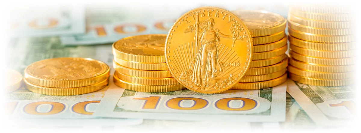 Stacks of American Gold Eagle coins atop $100 bills