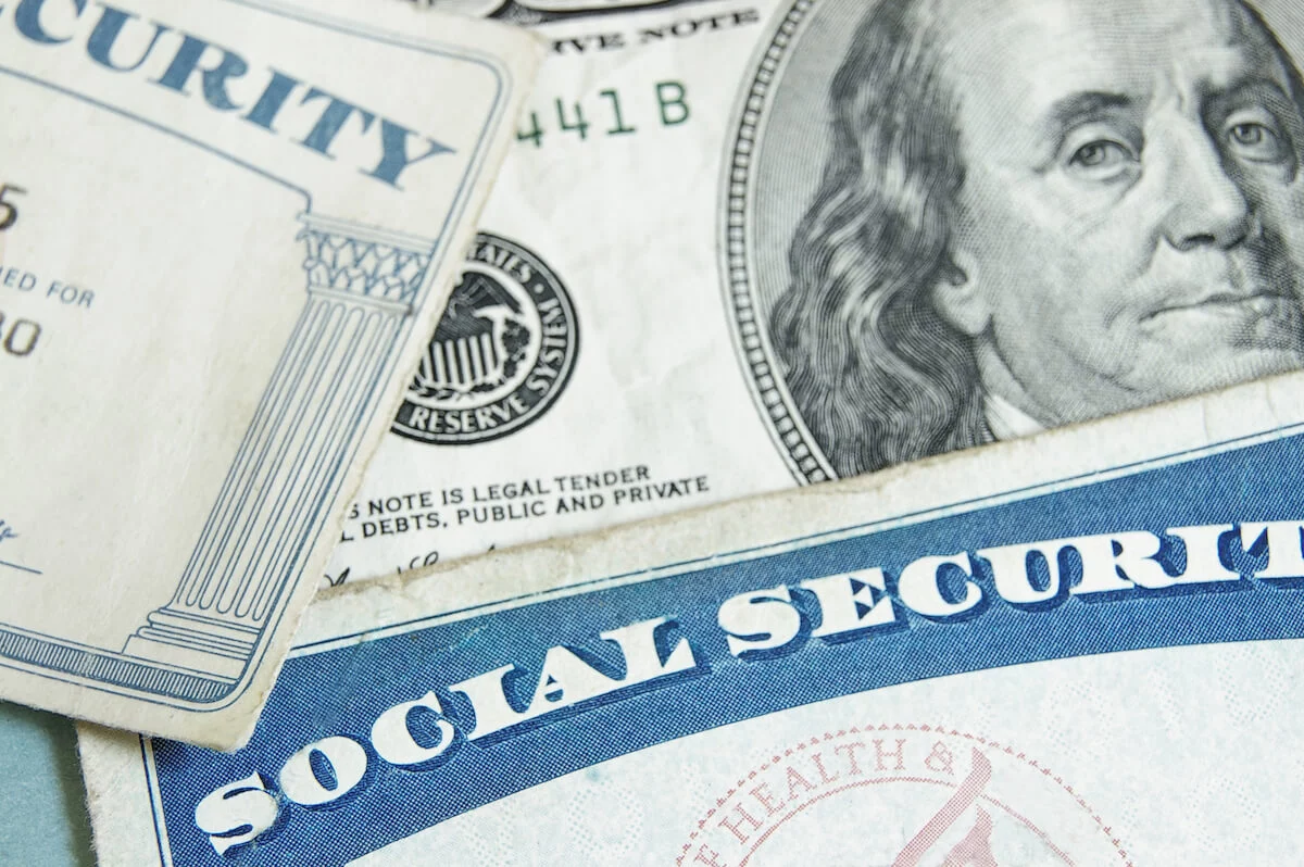 Social security cards stacked over $100 note