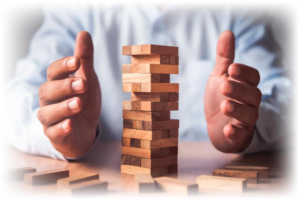 Business person holding hands on either side of block tower
