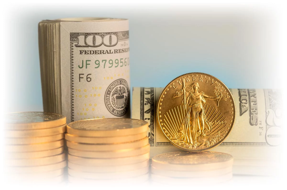 Stacks of Gold American Eagle coins and rolls of U.S. paper currency