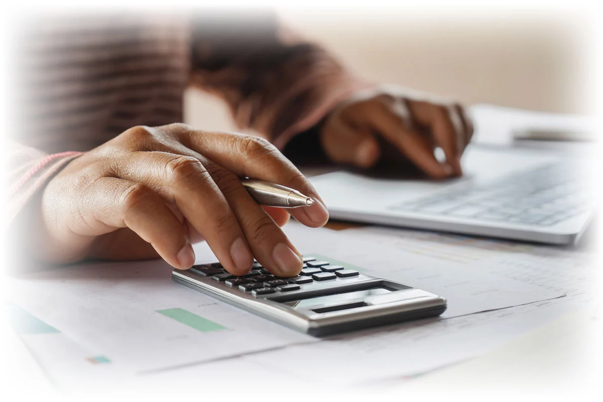 Close-up of hands using laptop and calculator