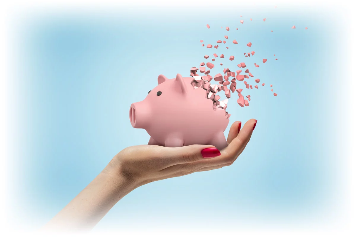 Woman's hand holding piggy bank that has started to disintegrate