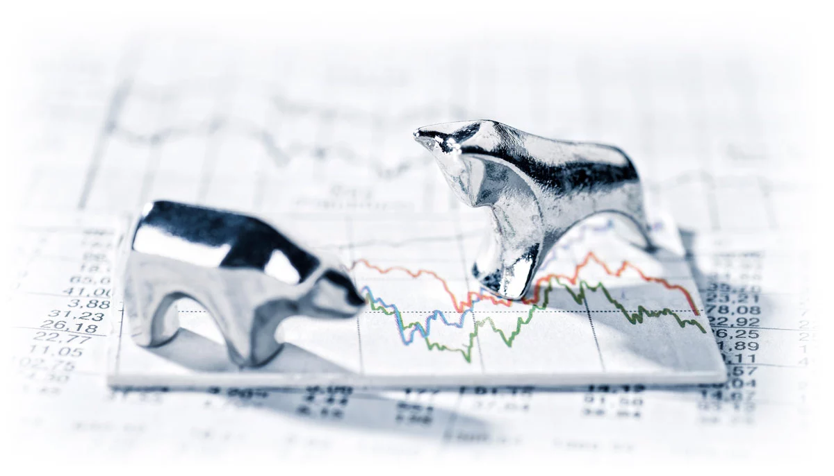 Silver bull and bear on top of market charts showing volatility
