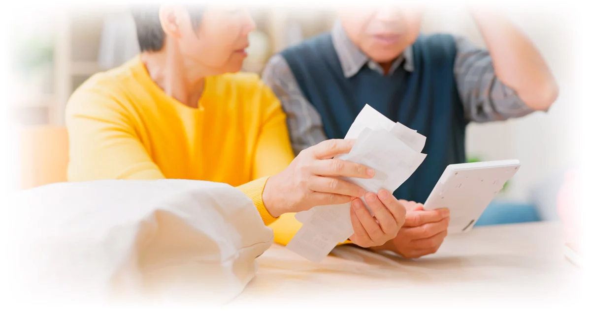 Elderly couple looking at receipts and calculator