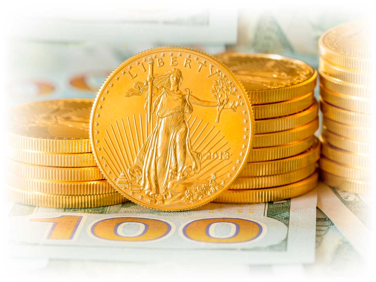 Stacks of Gold American Eagle coins over $100 notes