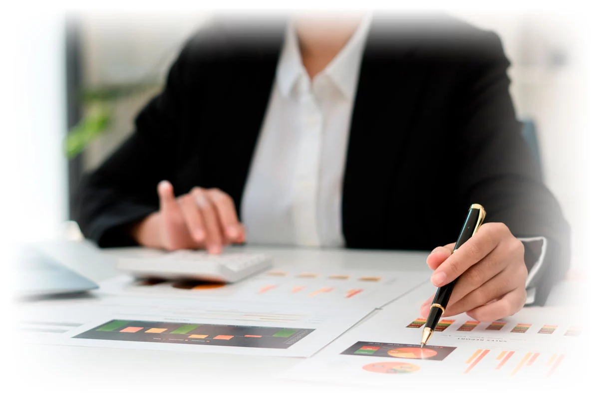 Business woman looking over printed data charts with pen and calculator