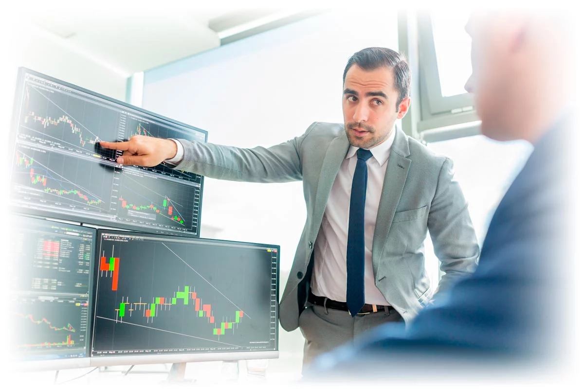 Financial analysts discussing stock data chart on computer screen