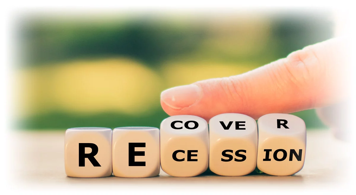 Finger tipping word blocks from "RECESSION" to "RECOVER"