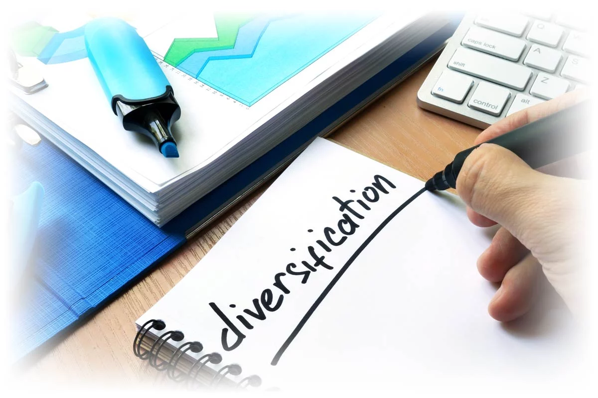 Hand underlining word "diversification" on notebook