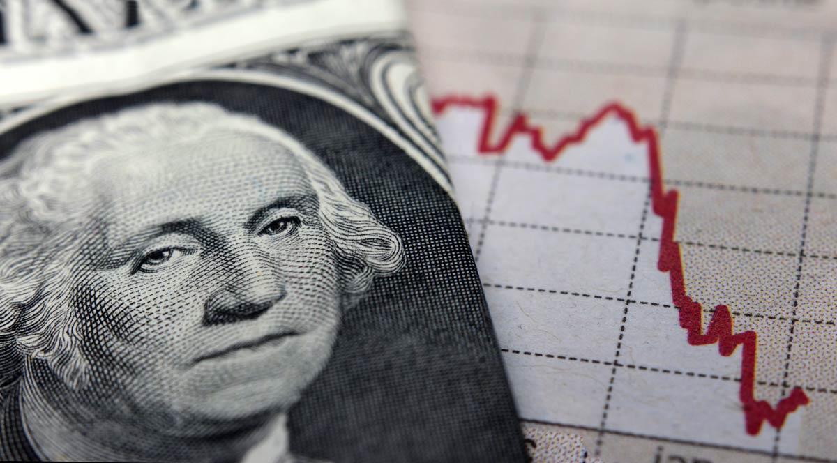 Close-up of U.S. dollar over negative-trending line chart