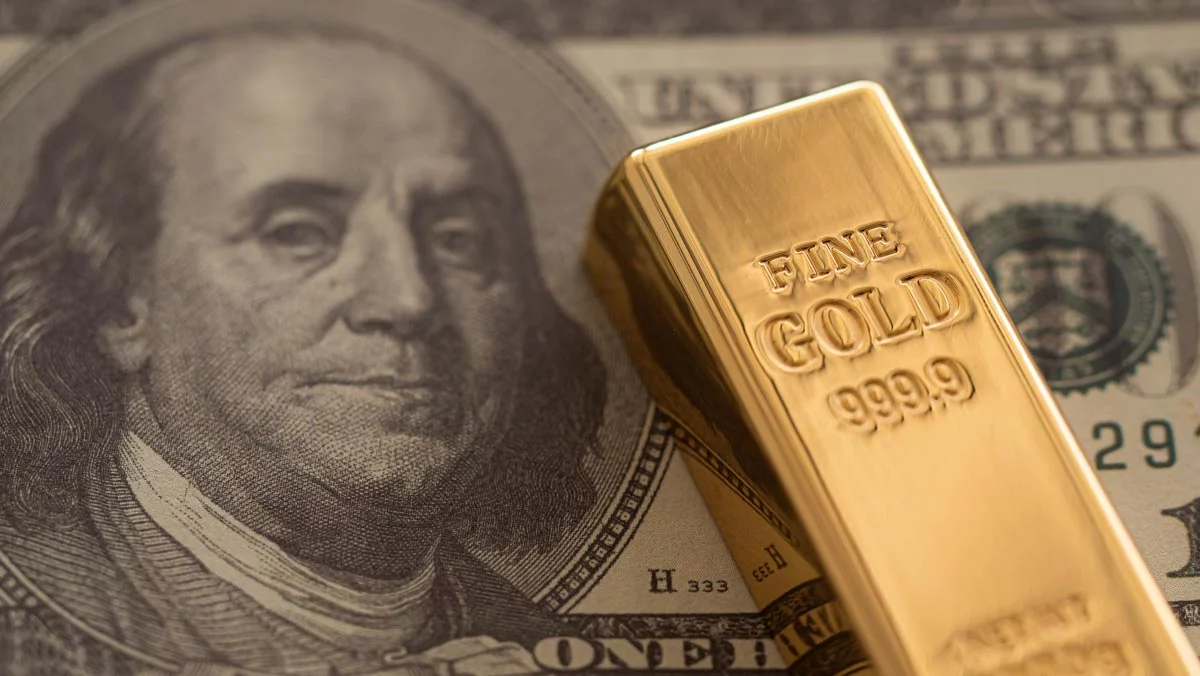 Gold bar over $100 note