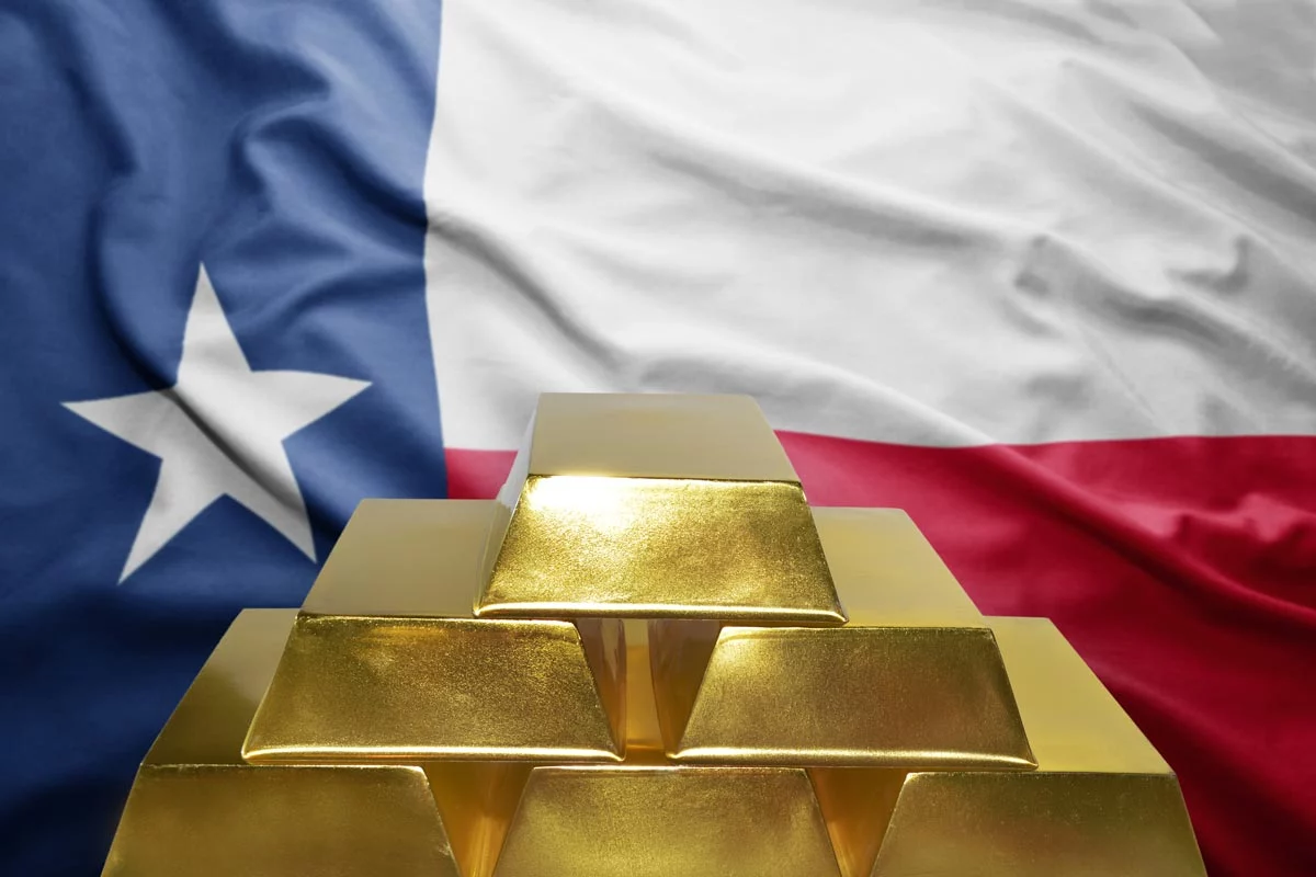Gold bars stacked in front of a Texas state flag