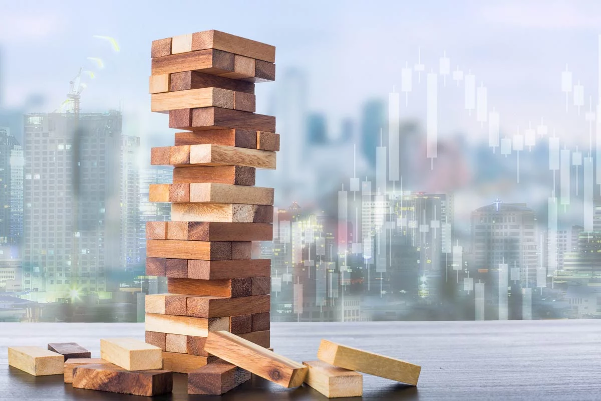 Block stacking game with several blocks gone in front of city skyline and stock data