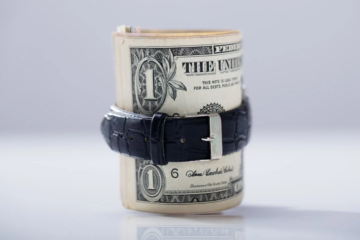 Roll of $1 notes surrounded by belt
